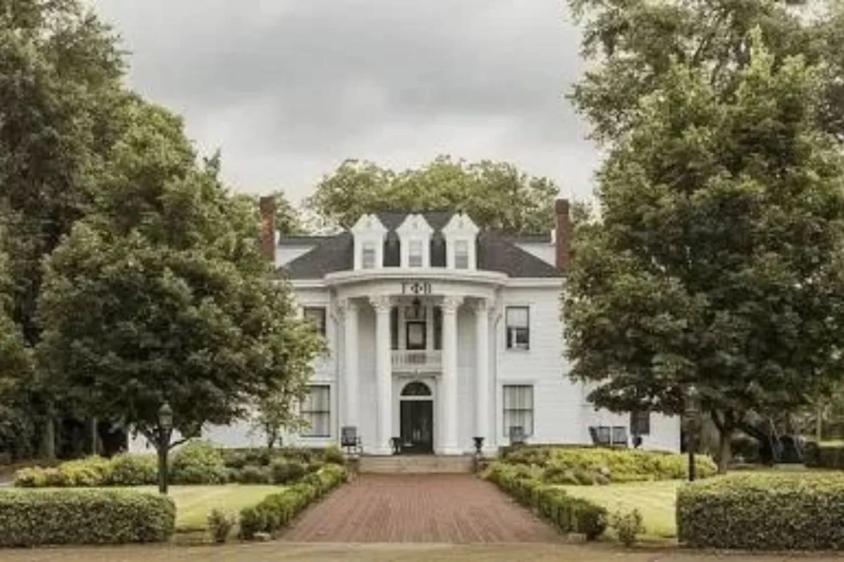 White-columned historic house with a brick walkway and mature trees in Athens, GA